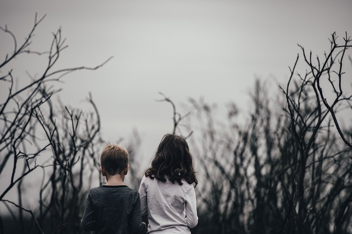 Boy and girl among bare branches