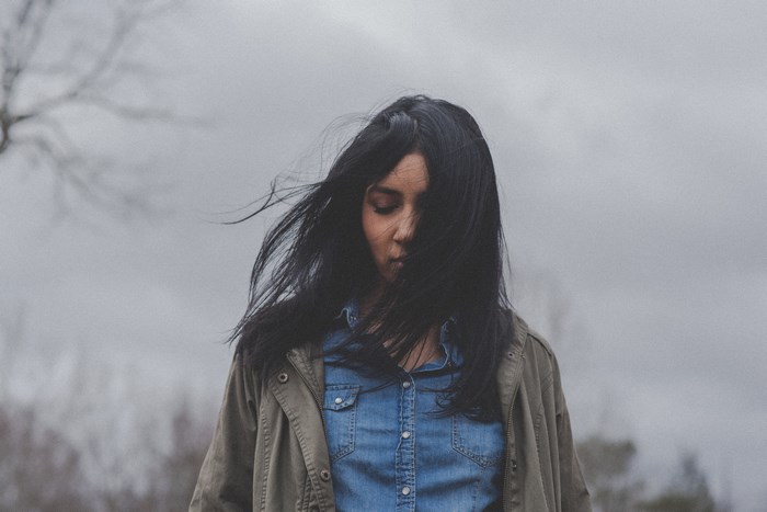 Woman with dark hair in a denim shirt and jacket