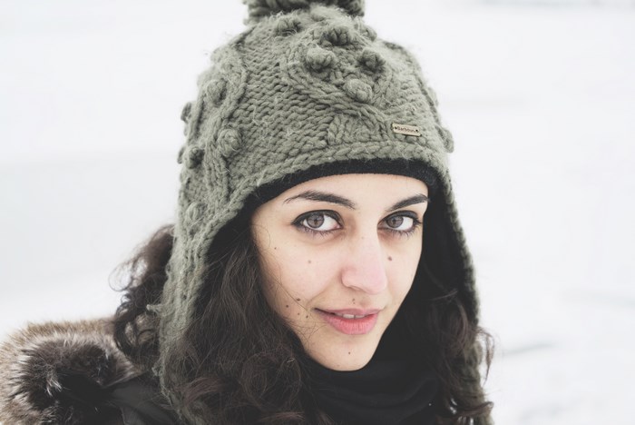 Woman wearing a knitted beanie in the snow