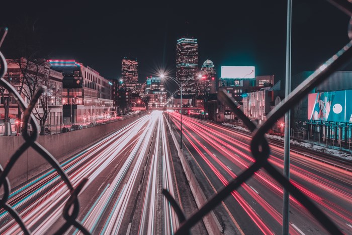 Cityscape with light trails on highway at night