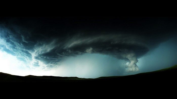 Tornado storm over a dark landscape