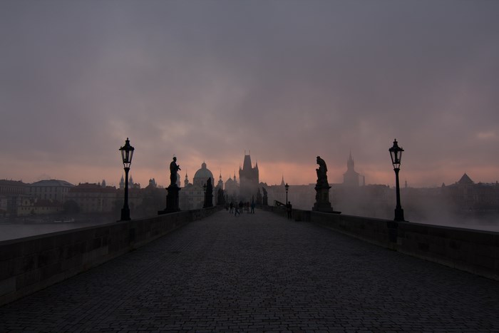 Charles Bridge in Prague at dawn with fog