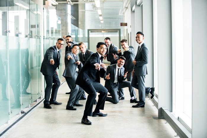 Group of men in suits posing in a hallway