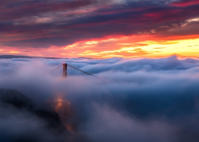 Golden Gate Bridge shrouded in fog during sunset