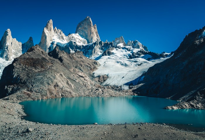 Turquoise lake and snow-capped mountains under a clear blue sky