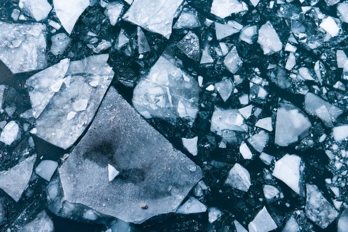 Aerial view of broken ice floes on dark water