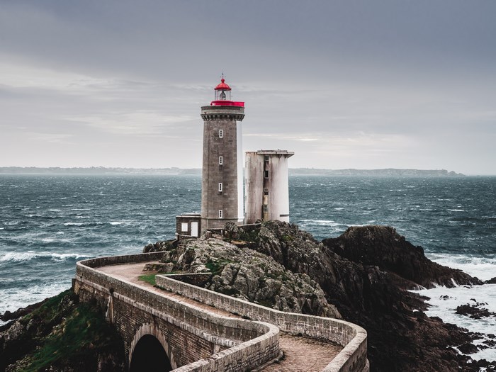 Lighthouse on a rocky coast with a stone path