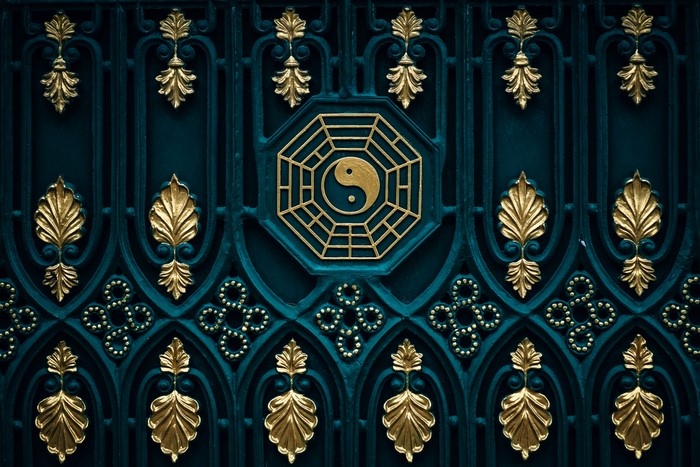 Ornate gate with gold Yin Yang symbol