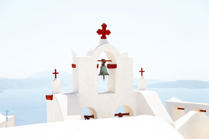 White bell tower with red crosses in Santorini