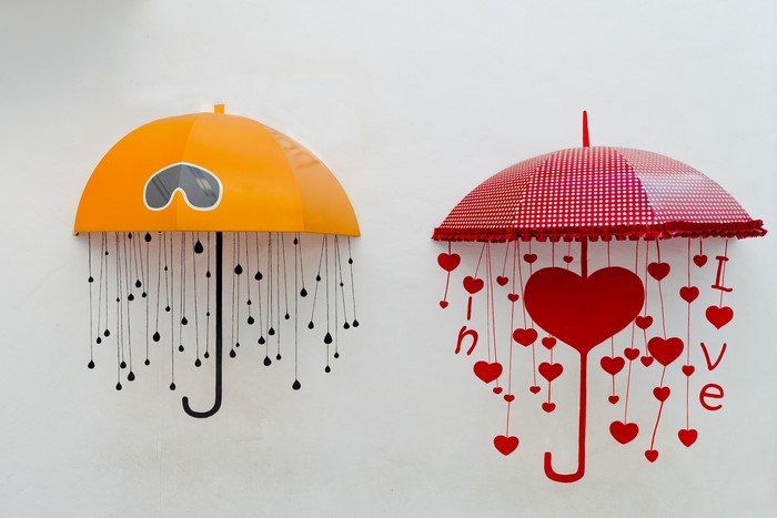 Two decorative umbrellas with hanging hearts and drops