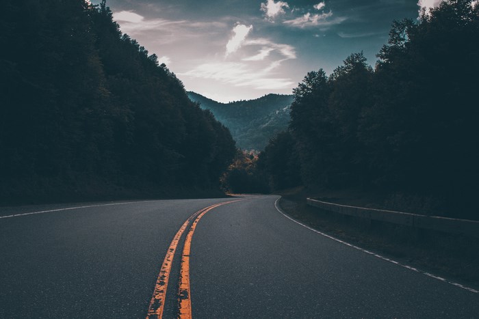 Winding mountain road through a dark forest