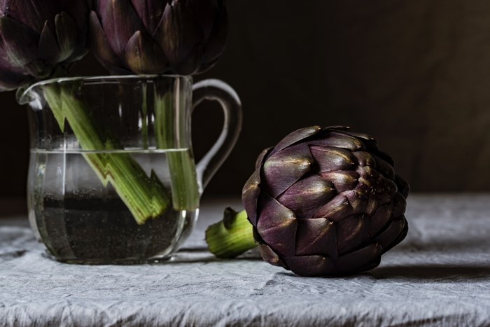 Artichokes in a glass pitcher with water