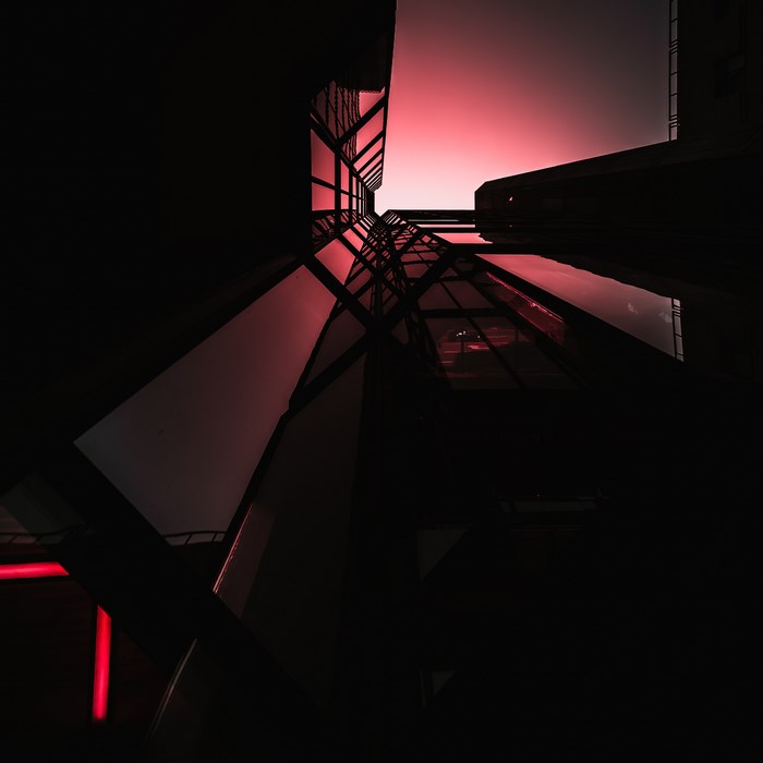 Dark modern building with red sky reflection