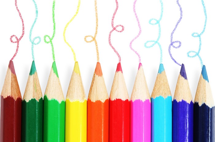 Colored pencils drawing colorful lines on white background