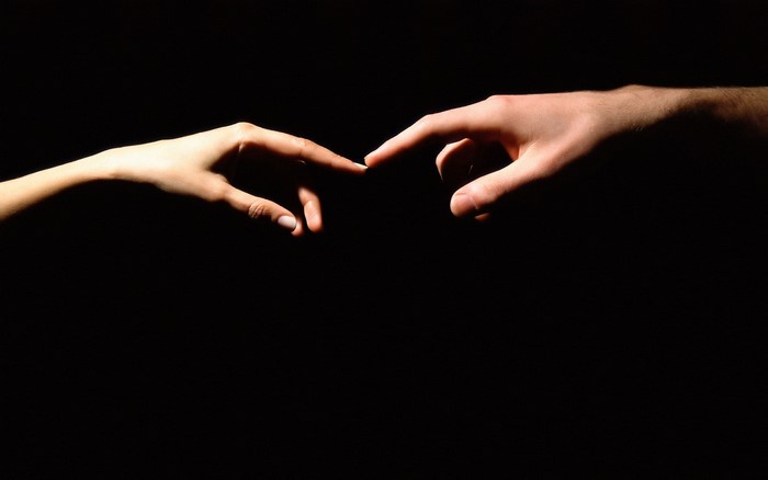 Two hands reaching out to touch