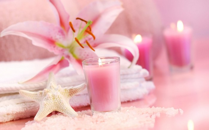 Pink lily flower with candles and starfish