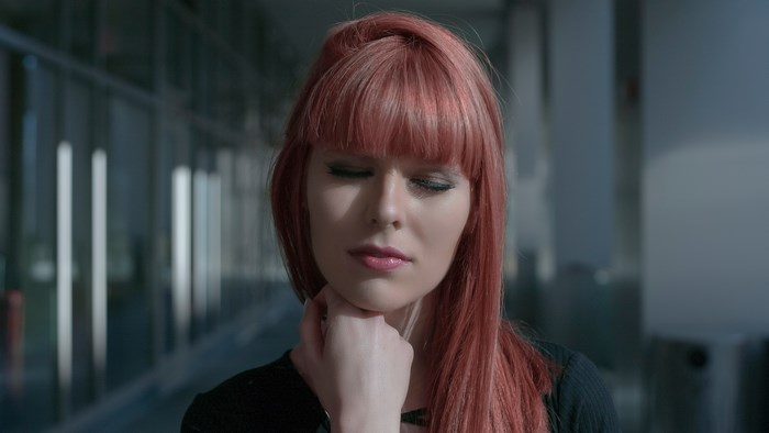Woman with red hair and eyes closed