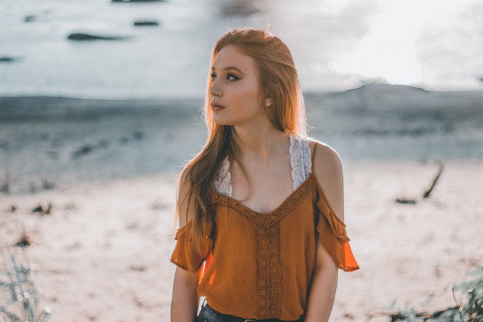 Young woman with red hair on a beach