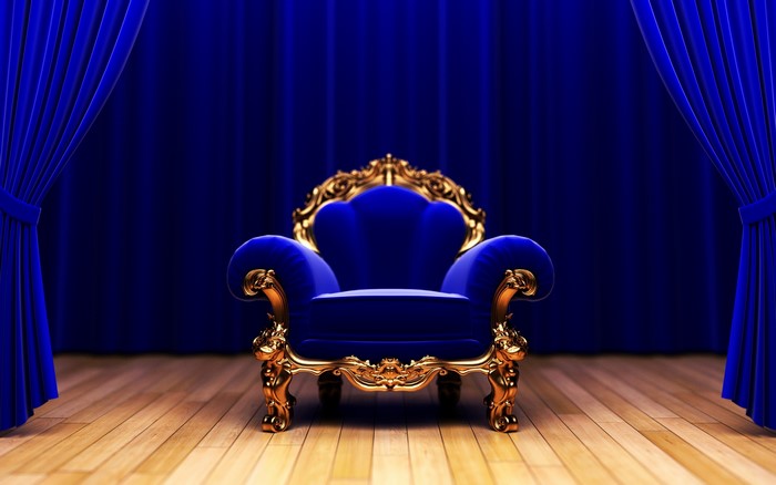 Royal blue throne chair with gold accents on wooden floor
