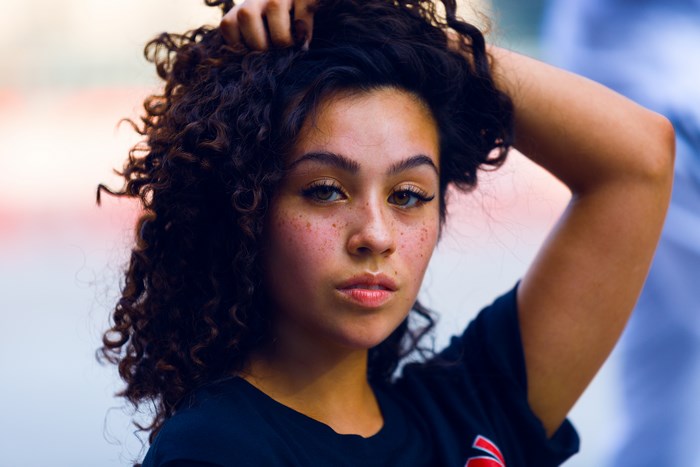Young woman with curly hair and freckles