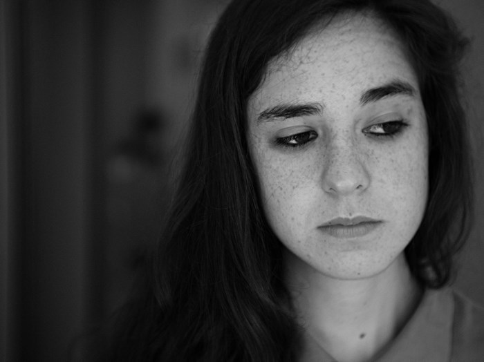 Woman with freckles looking down