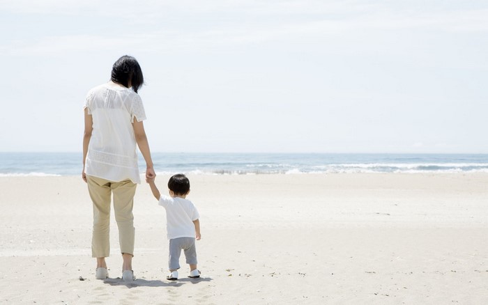 Mother and child walking on a beach