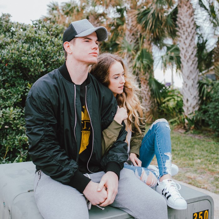 Couple sitting outdoors with palm trees