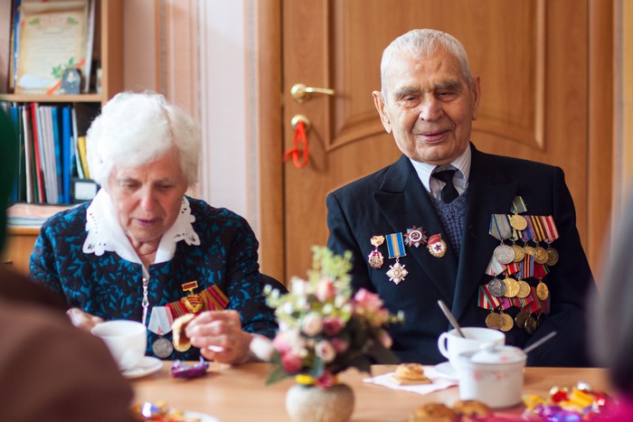 Elderly couple with medals at a table