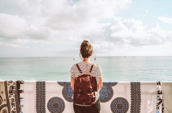Woman with backpack looking at the sea