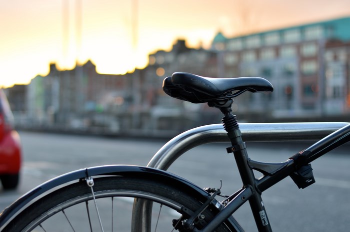Close up of a bicycle saddle and wheel in an urban setting
