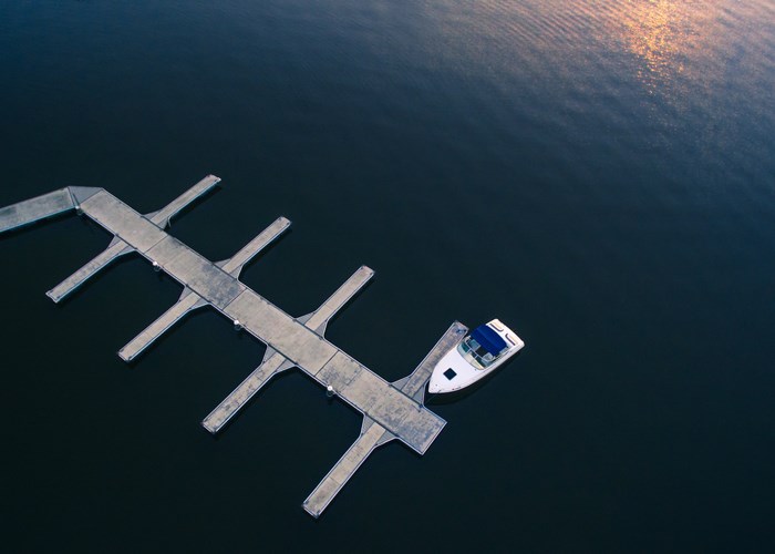 Aerial view of a boat docked at a concrete pier on the water