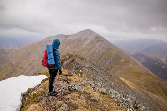Hiker with backpack on a mountain ridge