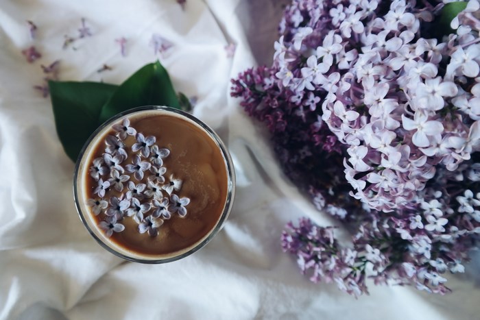 Coffee with lilac flowers and lilac bouquet