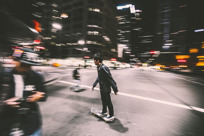 Man skateboarding at night in a city