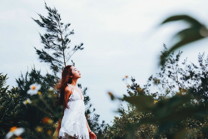 Woman in white dress in a windy natural setting