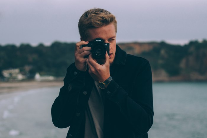Man with Sony camera taking a photo at the beach