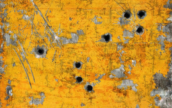 Yellow painted surface with bullet holes and scratches