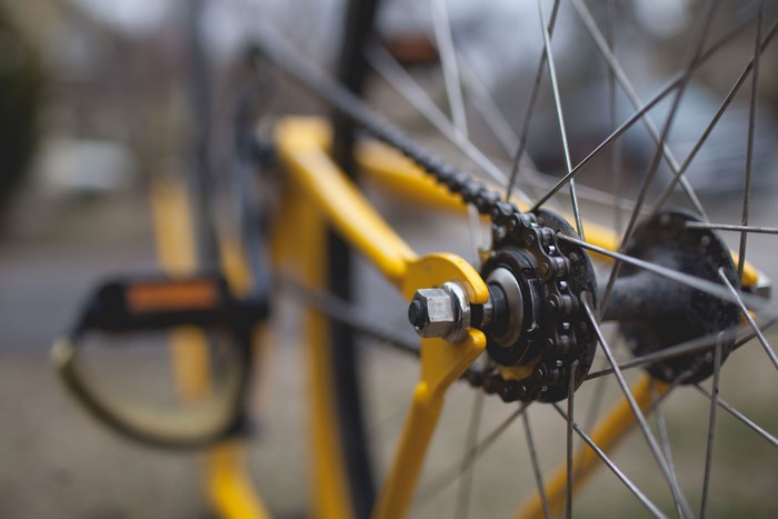 Close-up of a yellow bicycle's rear wheel and chain
