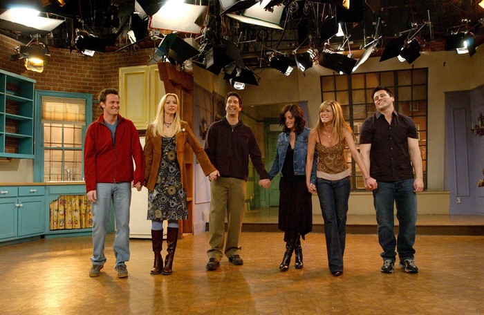 Friends cast holding hands on set