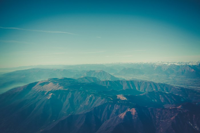 Aerial view of a vast mountain range under a hazy sky