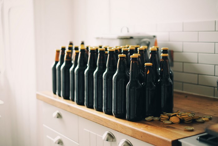 Bottles of craft beer lined up on a kitchen counter