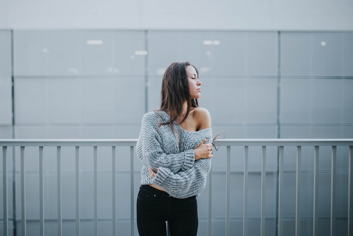 Woman in Gray Knit Sweater Leaning on Railing