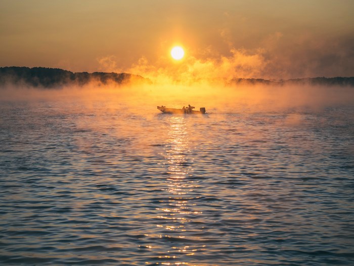 Boat in Foggy Sunrise Over Lake