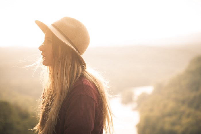 Woman in hat and sweater during golden hour