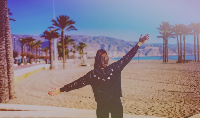 Woman with arms outstretched on a beach