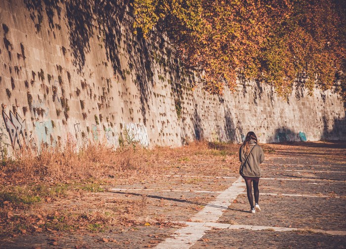 Woman walking on a path in Rome during autumn
