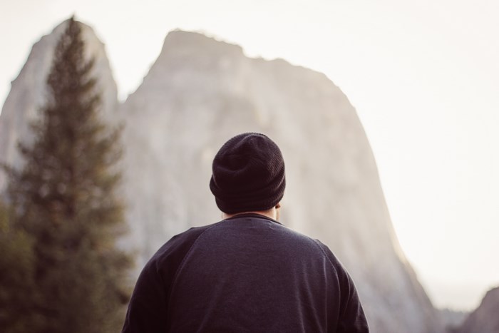 Man wearing a beanie looking at Yosemite mountains
