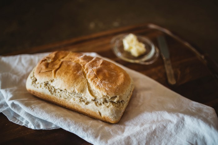 Loaf of bread with butter and knife on a table