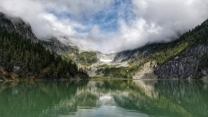 Misty mountains reflected in a calm lake