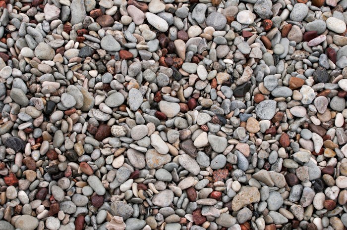 A close-up view of many small pebbles on a beach.